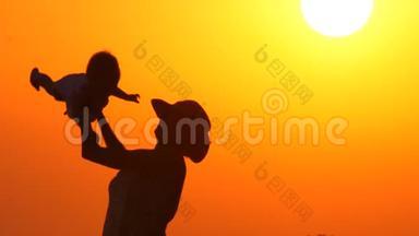 日落时分，母亲在海滩上和女儿玩耍。快乐育儿理念。抽象背景。暑假